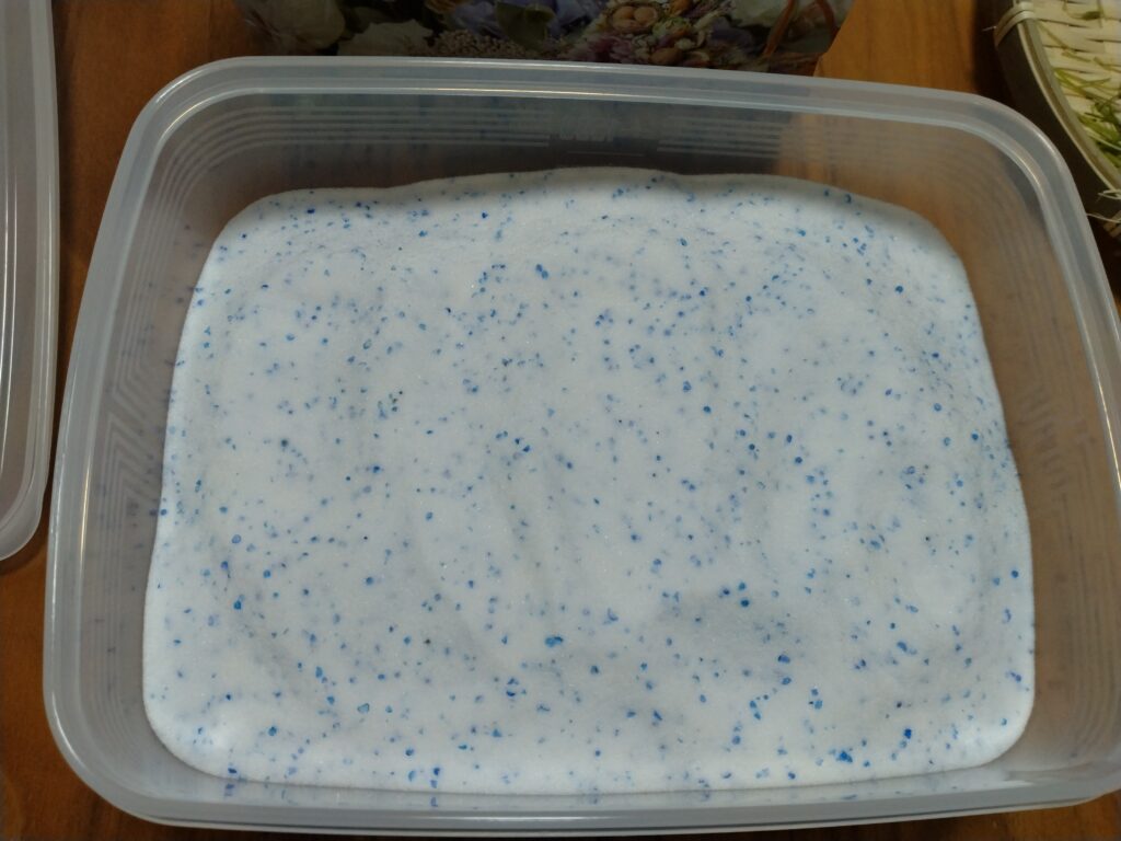 タッパーに入れた花をシリカゲルに埋めた画像
